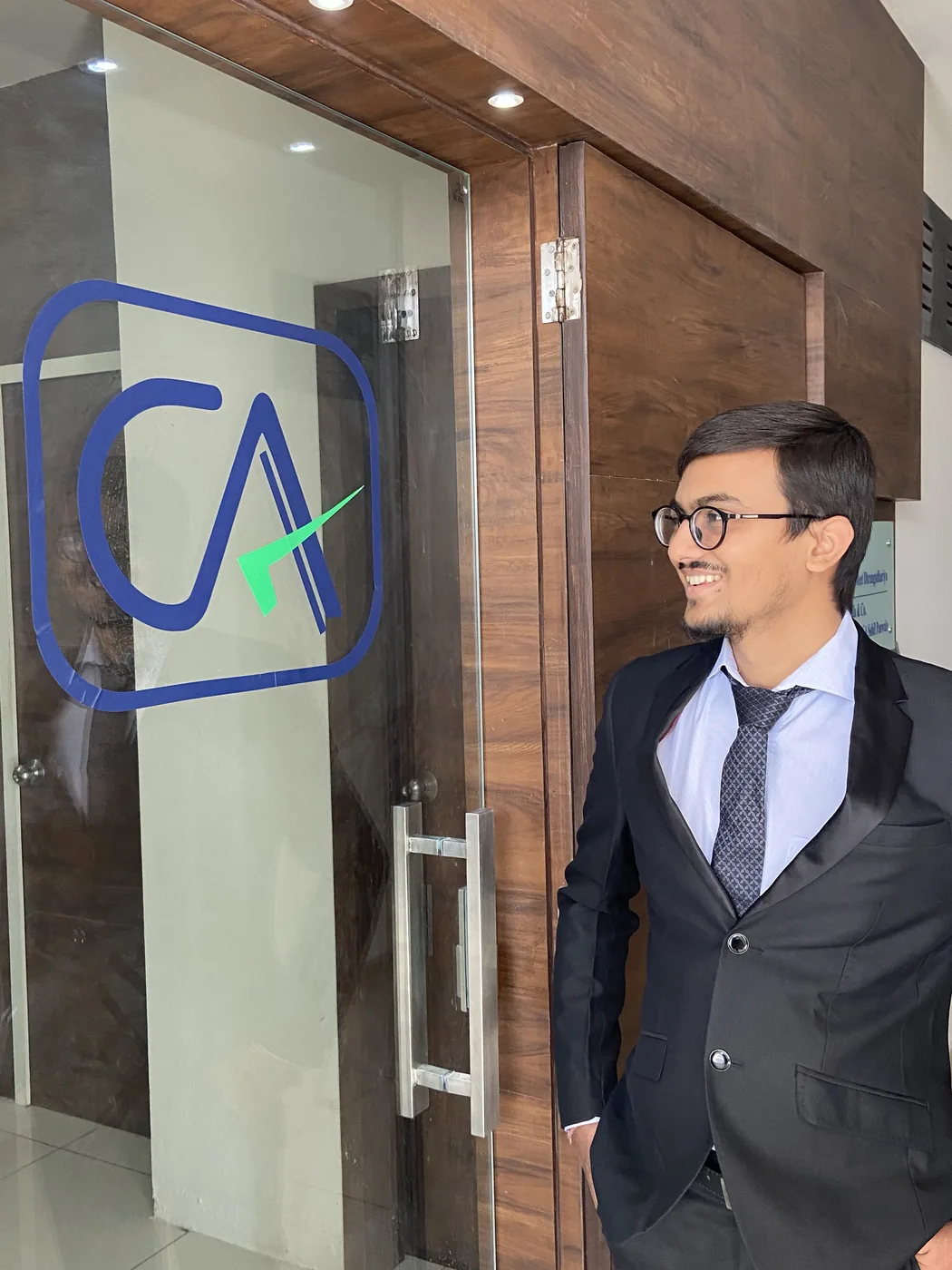 The glass entrance door of the office carrying the Chartered Accountant emblem