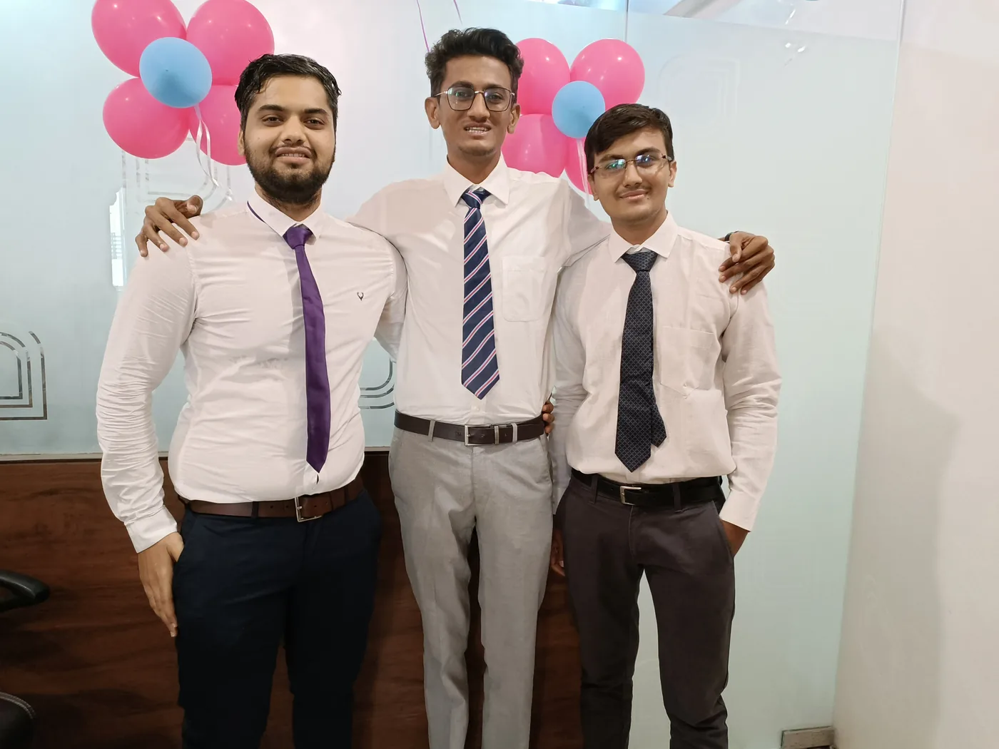 Three colleagues in formal dress together at the CSM & Co LLP office