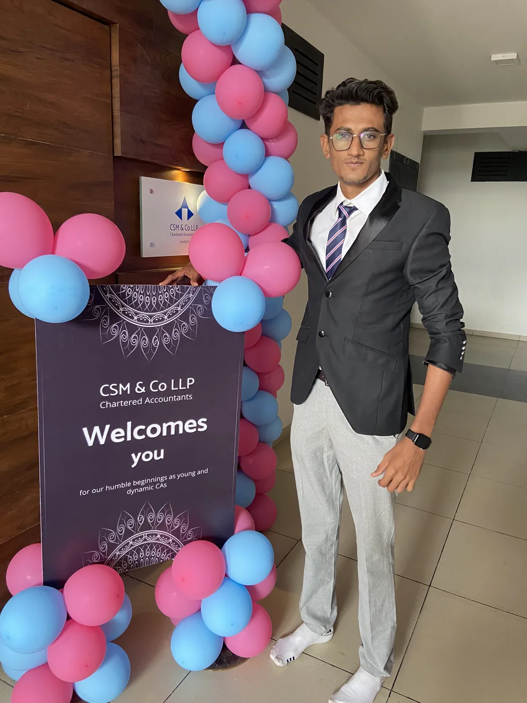 A CSM & Co LLP welcome banner beside a balloon arch at the office entrance